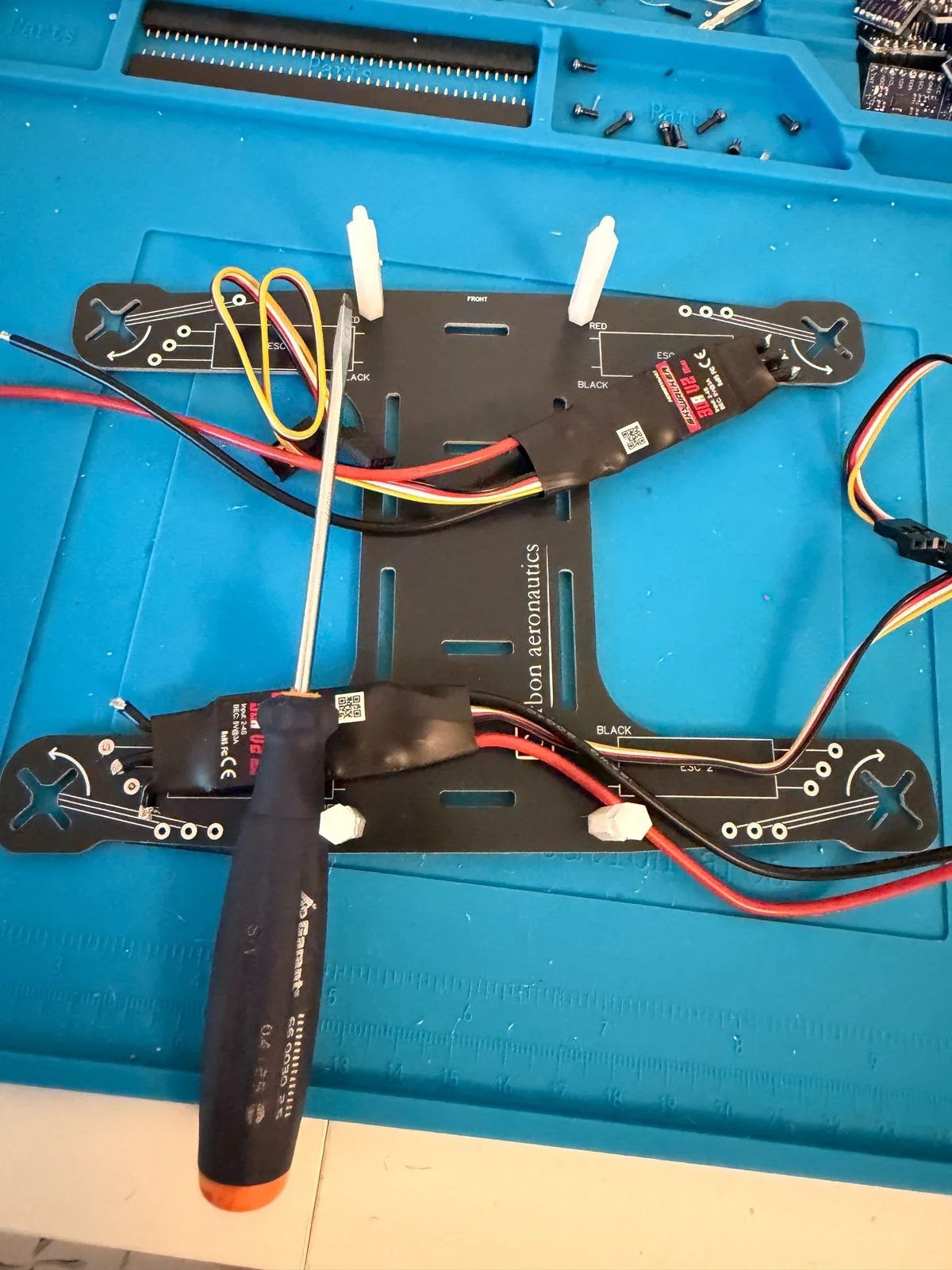 Quadrocopter-Rahmen mit montierten ESCs und Verkabelung auf einer blauen Arbeitsmatte